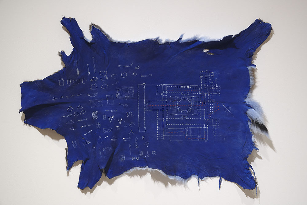 blue colored hide laid flat against a wall with schematics on the surface in white