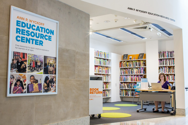 Photo of the Educator Resource Center at Seattle Art Museum with a staff person sitting at a desk and many shelve of books and resources behind them